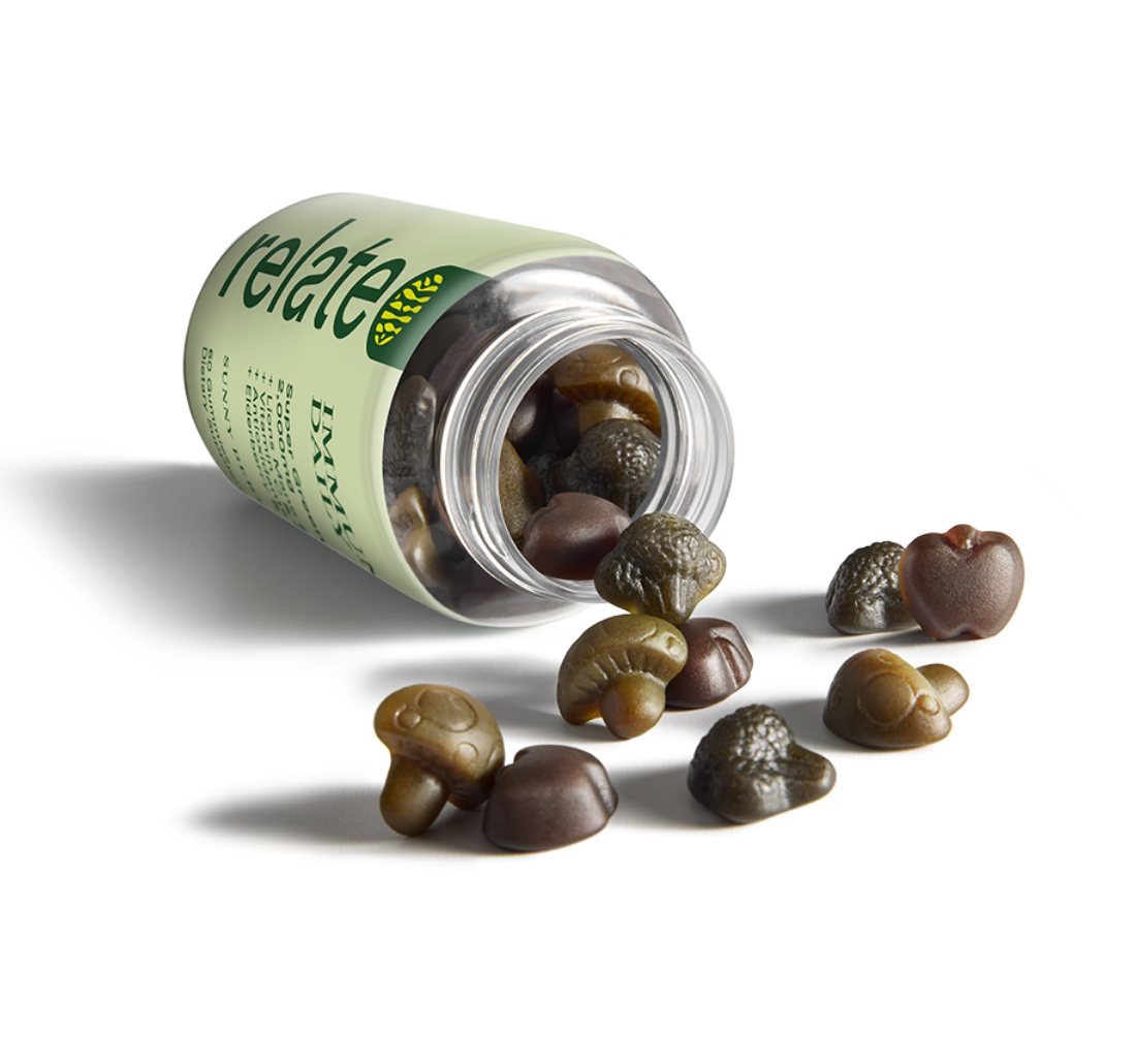 A 60-count bottle of sunny berry flavored gummies from the Relate brand, known as Immunity Daily, featuring a blend of super greens, lion's mane and reishi mushrooms, vitamin C and zinc, antioxidants, elderberry, and echinacea dietary supplements, spilled on a table