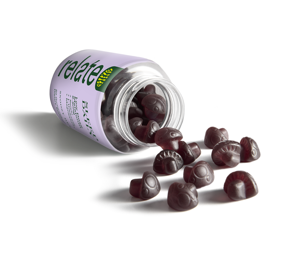 A bottle labeled "Relate Sleep Daily." It contains sleep dietary supplement gummies with low-dose melatonin (2.5mg), reishi, L-theanine, and magnesium, advertised as "Snoozy Berry" flavor, with 60 gummies per bottle spilled on a table