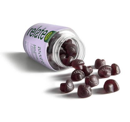 A bottle labeled "Relate Sleep Daily." It contains sleep dietary supplement gummies with low-dose melatonin (2.5mg), reishi, L-theanine, and magnesium, advertised as "Snoozy Berry" flavor, with 60 gummies per bottle spilled on a table